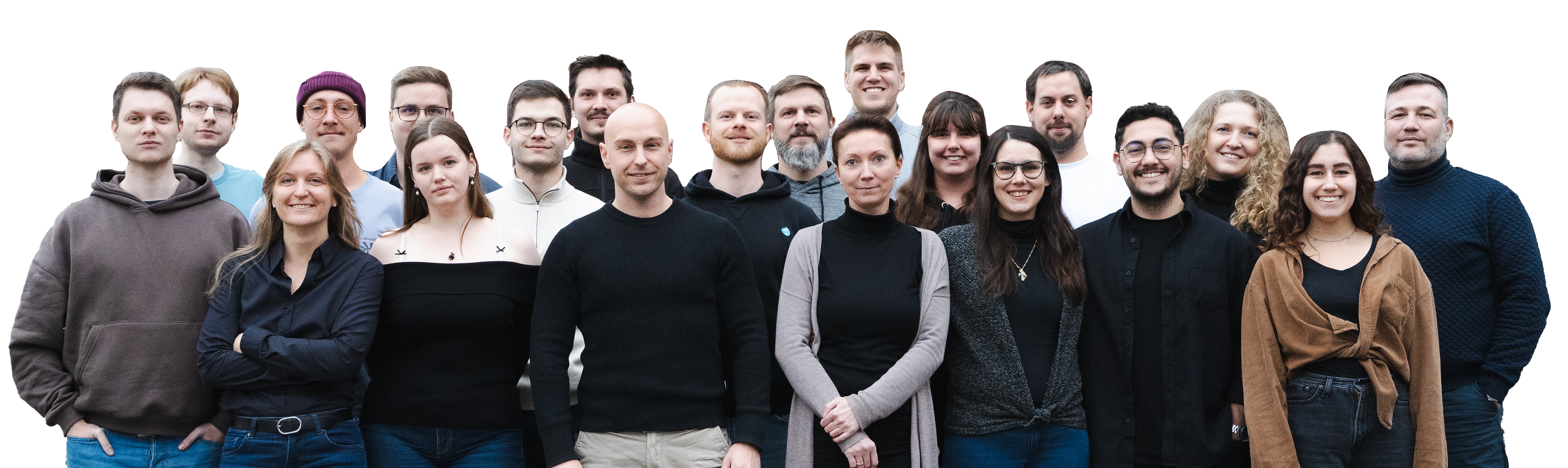 Eine Gruppe von 13 Männern und 7 Frauen steht zusammen und lacht in die Kamera. Sie tragen legere, vornehmlich dunkle Alltagskleidung