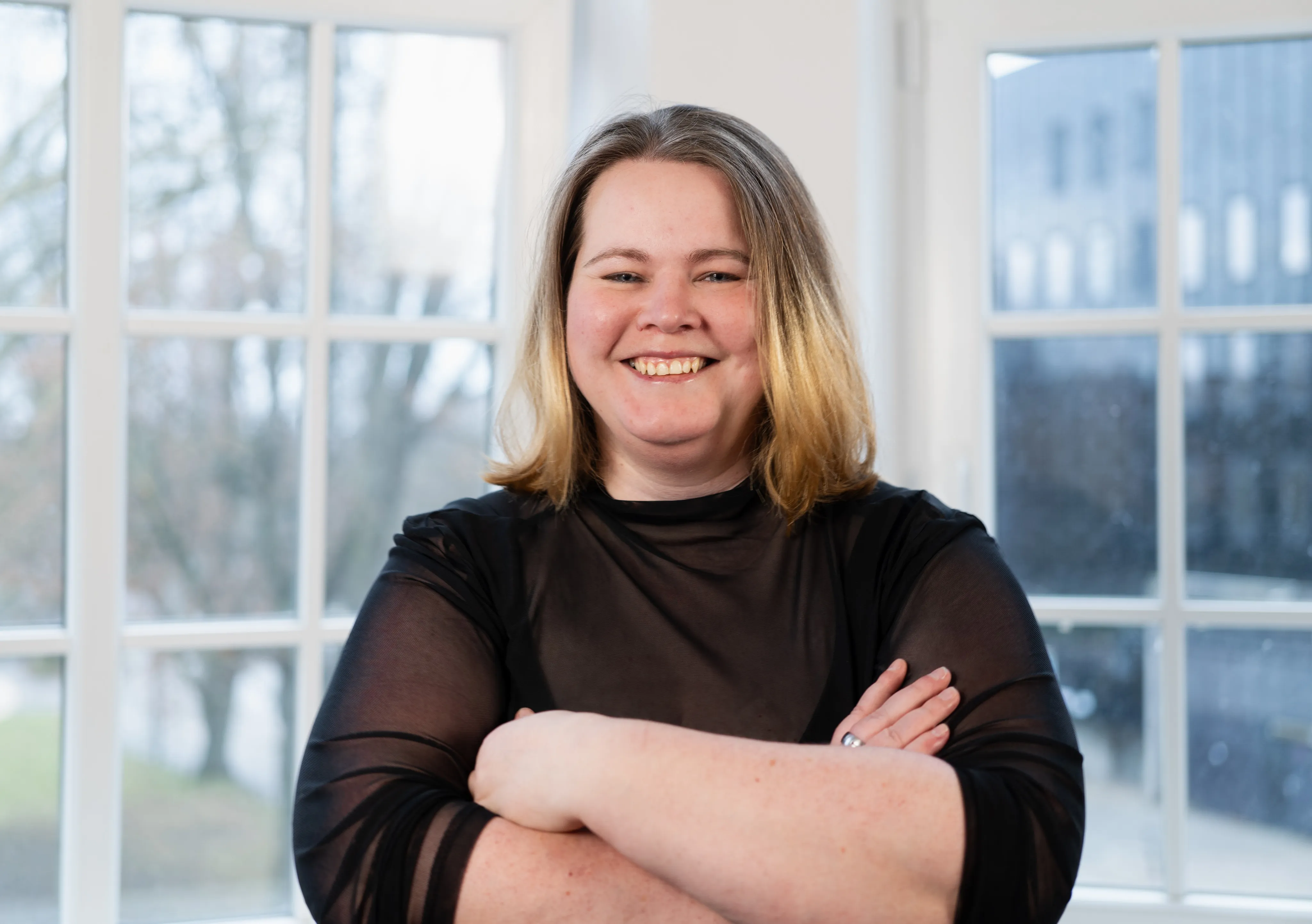 Johanna Reihs schaut freundlich in die Kamera. Sie trägt schulterlange blonde Haare und ein schwarzes Oberteil.